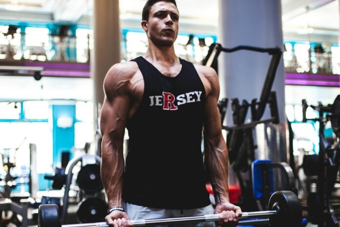 man in black tank top and gray pants