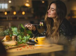 woman holding fork in front table